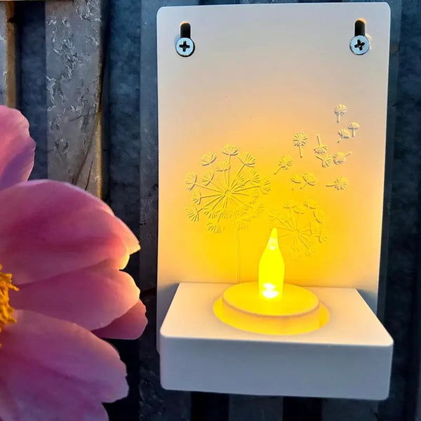 Wand-Windlicht mit Pusteblumen-Motiv, LED-Licht und rosa Blüte im Vordergrund